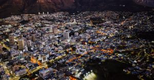 A stunning aerial view of Cape Town city lights at night against Table Mountain.